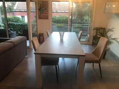 a dining table and chairs in a living room at Les Cerisiers. in Aix-en-Provence
