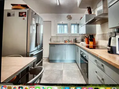 a kitchen with blue cabinets and stainless steel appliances at Les Cerisiers. in Aix-en-Provence