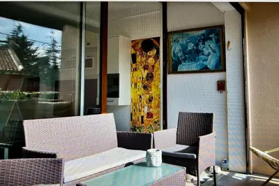 a patio with chairs and a table and a painting at Les Cerisiers. in Aix-en-Provence