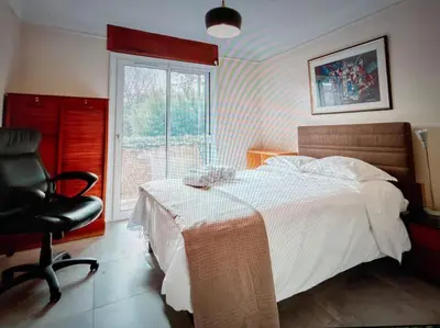 a bedroom with a bed and a chair and a window at Les Cerisiers. in Aix-en-Provence