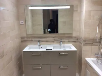 a person taking a picture of a bathroom with a sink at Les Cerisiers. in Aix-en-Provence