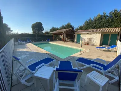 a patio with chairs and a swimming pool at Gîte Lou Pastre in Aureille