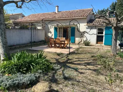 a house with a table and chairs in the yard at Gîte Lou Pastre in Aureille