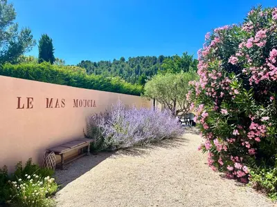a bench sitting on the side of a wall with flowers at Mas Moucia in Mormoiron