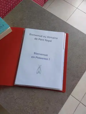 a book sitting on the floor with a sign on it at Maison 3 pièces domaine golf Pont Royal in Mallemort