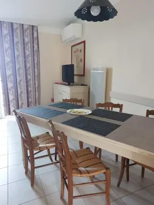 a dining room with a table with chairs and a television at Maison 3 pièces domaine golf Pont Royal in Mallemort