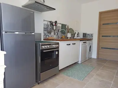 a kitchen with a stainless steel refrigerator and a dishwasher at La bastide des Roman in Vernègues