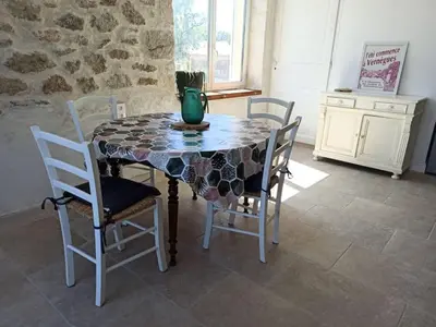 a dining room table with chairs and a vase on it at La bastide des Roman in Vernègues