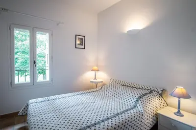 a white bedroom with a bed and two lamps at Le Mas de Jalique - Isle-sur-la-Sorgue in LʼIsle-sur-la-Sorgue