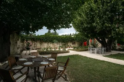 a table with plates on it in a garden at Le Mas de Jalique - Isle-sur-la-Sorgue in LʼIsle-sur-la-Sorgue
