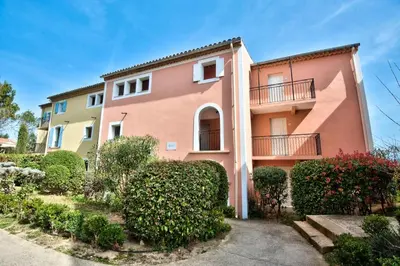 a pink building with bushes in front of it at Village Pont Royal en Provence - maeva Home - Appartement charmant et climatisé 2 pièces 4 personnes - Prestige - super Home MAE-4884 in Mallemort