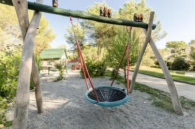 a swing yard with two swings and a basket at Village Pont Royal en Provence - maeva Home - Appartement charmant et climatisé 2 pièces 4 personnes - Prestige - super Home MAE-4884 in Mallemort