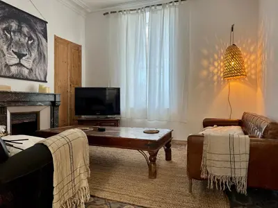 a living room with a couch a table and a tv at La Maison de Lola in Carpentras