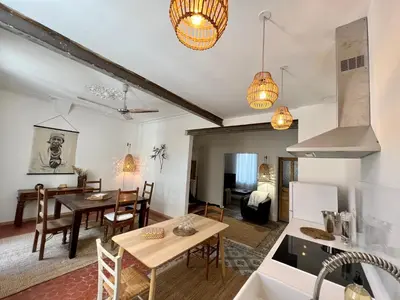 a kitchen and living room with a table and a dining room at La Maison de Lola in Carpentras