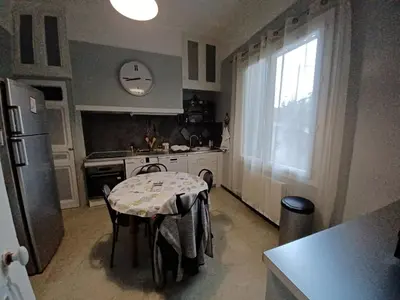a small kitchen with a table and a refrigerator at maison 4 à 6 personnes proche village in Pélissanne