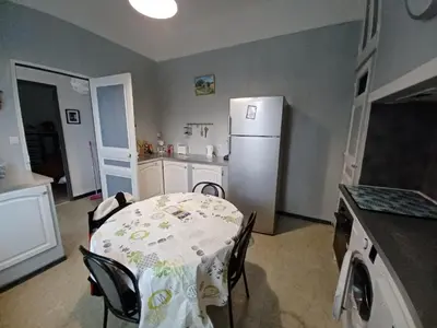 a kitchen with a table and a white refrigerator at maison 4 à 6 personnes proche village in Pélissanne