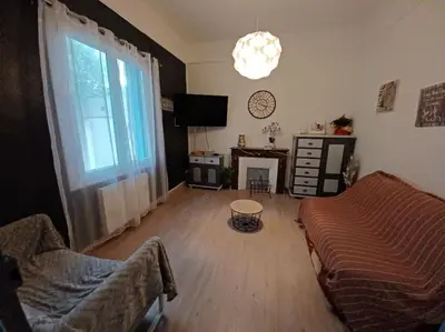 a living room with a couch and a table and a window at maison 4 à 6 personnes proche village in Pélissanne