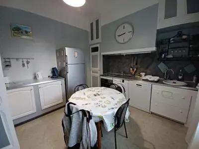a kitchen with a table and a clock on the wall at maison 4 à 6 personnes proche village in Pélissanne