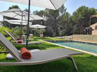a group of chairs and umbrellas next to a pool at Villa de luxe en Luberon - Piscine chauffée in Puget