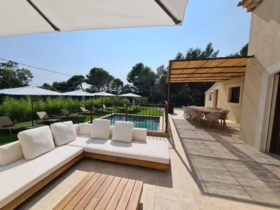a patio with a couch and a table and a pool at Villa de luxe en Luberon - Piscine chauffée in Puget