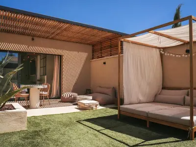 an outdoor patio with a couch and an umbrella at Love in L'Isle/Sorgue L'Aurore in LʼIsle-sur-la-Sorgue