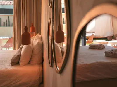 a bedroom with a bed with pillows and a mirror at Love in L'Isle/Sorgue L'Aurore in LʼIsle-sur-la-Sorgue
