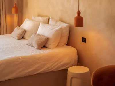 a bedroom with a bed with white pillows on it at Love in L'Isle/Sorgue L'Aurore in LʼIsle-sur-la-Sorgue