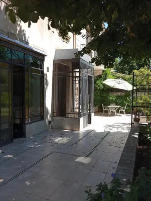 a building with a patio with a table and an umbrella at Chez Fleur in Avignon