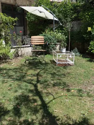 a bench and an umbrella in a yard at Chez Fleur in Avignon