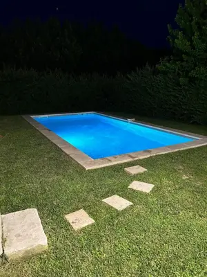 a blue swimming pool in the grass at night at Moun Cabanoun in Carpentras