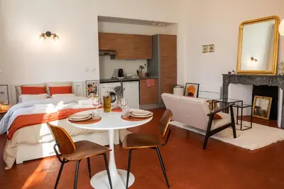 a bedroom with a bed and a table and chairs at Superbe appartement rénové et cosy à 10mn de Saint-Rémy de Provence in Noves