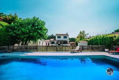 a large blue swimming pool in front of a house at Villa le Thor Piscine Billard Sauna et Jacuzzi in Le Thor