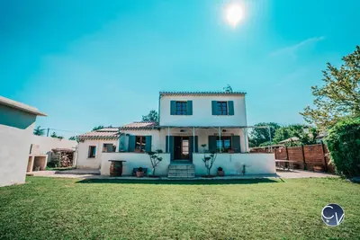 a large white house with a grass yard at Villa le Thor Piscine Billard Sauna et Jacuzzi in Le Thor