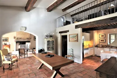 a living room with a table and a kitchen at In Gordes, facing the entire Luberon Park a beautiful 5 bedrooms house in Gordes