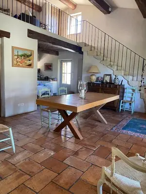a dining room with a wooden table and stairs at In Gordes, facing the entire Luberon Park a beautiful 5 bedrooms house in Gordes