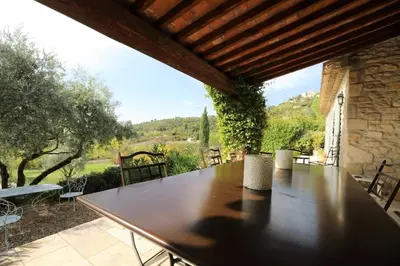 a large wooden table on a patio with a view at In Gordes, facing the entire Luberon Park a beautiful 5 bedrooms house in Gordes