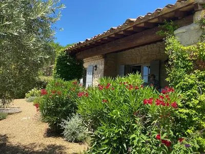 a house with a bunch of flowers in front of it at In Gordes, facing the entire Luberon Park a beautiful 5 bedrooms house in Gordes