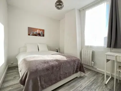 a white bedroom with a bed and a window at AptCityStay in Apt