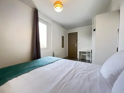 a bedroom with a large white bed and a window at AptCityStay in Apt