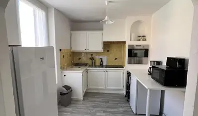 a kitchen with white cabinets and a white refrigerator at AptCityStay in Apt