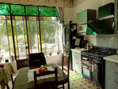 a kitchen with a table and some green glass windows at Chez Fleur in Avignon