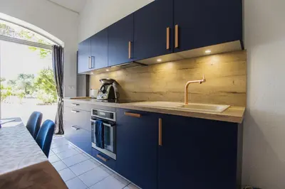 a kitchen with blue cabinets and a sink at Gite Grand Luberon chez Manon en Luberon - Vacation rental in guest house in Lagnes