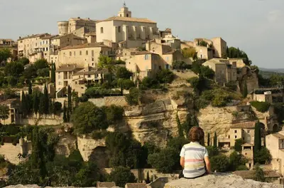 a woman sitting on a rock looking at a mountain at La petite Maison de Gordes in Gordes
