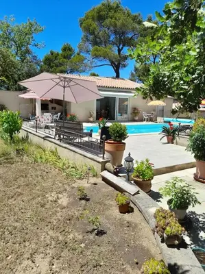 a house with a pool and a patio with plants at Villa le Bosquet en Luberon. in Ménerbes
