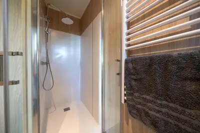 a bathroom with a shower and a glass door at Le Chant des Pins Lodge & Spa Massif de l'Etoile in Saint-Marc-Jaumegarde