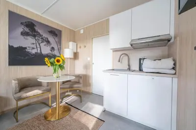 a kitchen with a table with a vase of flowers on it at Le Chant des Pins Lodge & Spa Massif de l'Etoile in Saint-Marc-Jaumegarde