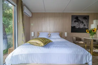 a bedroom with a white bed with a yellow pillow at Le Chant des Pins Lodge & Spa Massif de l'Etoile in Saint-Marc-Jaumegarde