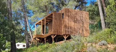 a tree house in the middle of a forest at Le Chant des Pins Lodge & Spa Massif de l'Etoile in Saint-Marc-Jaumegarde