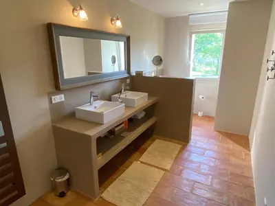 a bathroom with two sinks and a mirror at Chante Coucou in Saint-Saturnin-les-Apt