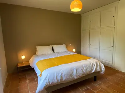 a bedroom with a bed with a yellow blanket at Chante Coucou in Saint-Saturnin-les-Apt